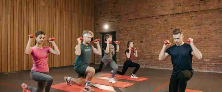 Indoor group workout session with dumbbells focusing on strength and fitness., tags: groepsfitness en - pexel